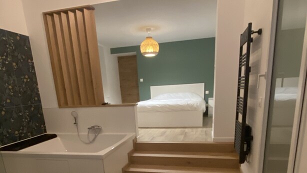 A modern bathroom with a bathtub, shower, and a large mirror. - Charming house on the Opal Coast, 5 minutes from the beach by car (Wimille)