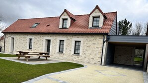 A stone building with a red-tiled roof, a stone bench, and a gravel driveway. - Charming house on the Opal Coast, 5 minutes from the beach by car (Wimille)