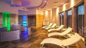 Un spa moderno con una zona de recepción, sillones de masaje y un amplio ventanal con vistas.