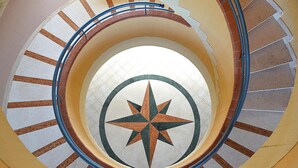 A spiral staircase with a central star design on the floor.