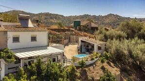 A residential area with a white house featuring a solar panel, a swimming pool, and a view of hilly terrain in the background. - Pet friendly home in Sayalonga (Sayalonga)