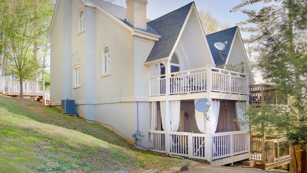 A two-story house with a balcony, a chimney, and a satellite dish. - 2BR/2.5BA, clean hot tub, spa tub, 1 mi to Pkway,10min to GSMNP, arcade,fire pit (Pigeon Forge)