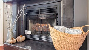 A fireplace with a basket and decorative pumpkins. - 2BR/2.5BA, clean hot tub, spa tub, 1 mi to Pkway,10min to GSMNP, arcade,fire pit (Pigeon Forge)