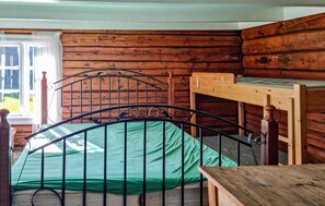 A wooden cabin room with a metal bed frame, a bunk bed, and a window with curtains. - 3 bedroom beautiful home in Bjelland (Bjelland)