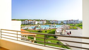 A hotel with a large swimming pool, multiple buildings, and a well-maintained lawn. - Nice apartment in Scanzano Jonico (Scanzano Jonico)