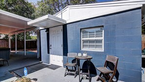 Una casa blu con portico coperto, una porta e una finestra.