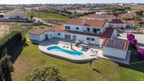 A large house with a swimming pool, surrounded by a well-maintained lawn and a vineyard in the background. - Villa with private pool and large garden (Ribamar)