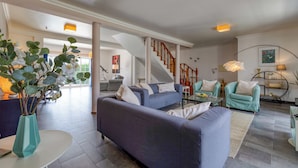 A spacious living room with a large sofa, a coffee table, and a staircase leading to another level. - Villa with private pool and large garden (Ribamar)