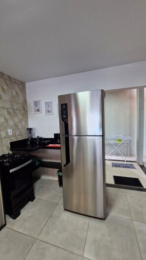 Eine moderne Küche mit einem Edelstahl-Kühlschrank, einem Gasherd und einer Kaffeemaschine.