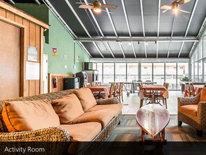 Relax in this spacious room with a sofa set, coffee table, and chairs, plus a kitchenette area with a refrigerator and microwave.