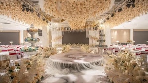 A wedding venue with a central round table, floral decorations, and white tablecloths. - Danjiangkou Guanlan International Hotel（Hanjiang Avenue storefront） (Danjiangkou)