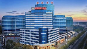 A modern hotel with multiple floors, a prominent entrance, and a large sign at the top. - Danjiangkou Guanlan International Hotel（Hanjiang Avenue storefront） (Danjiangkou)