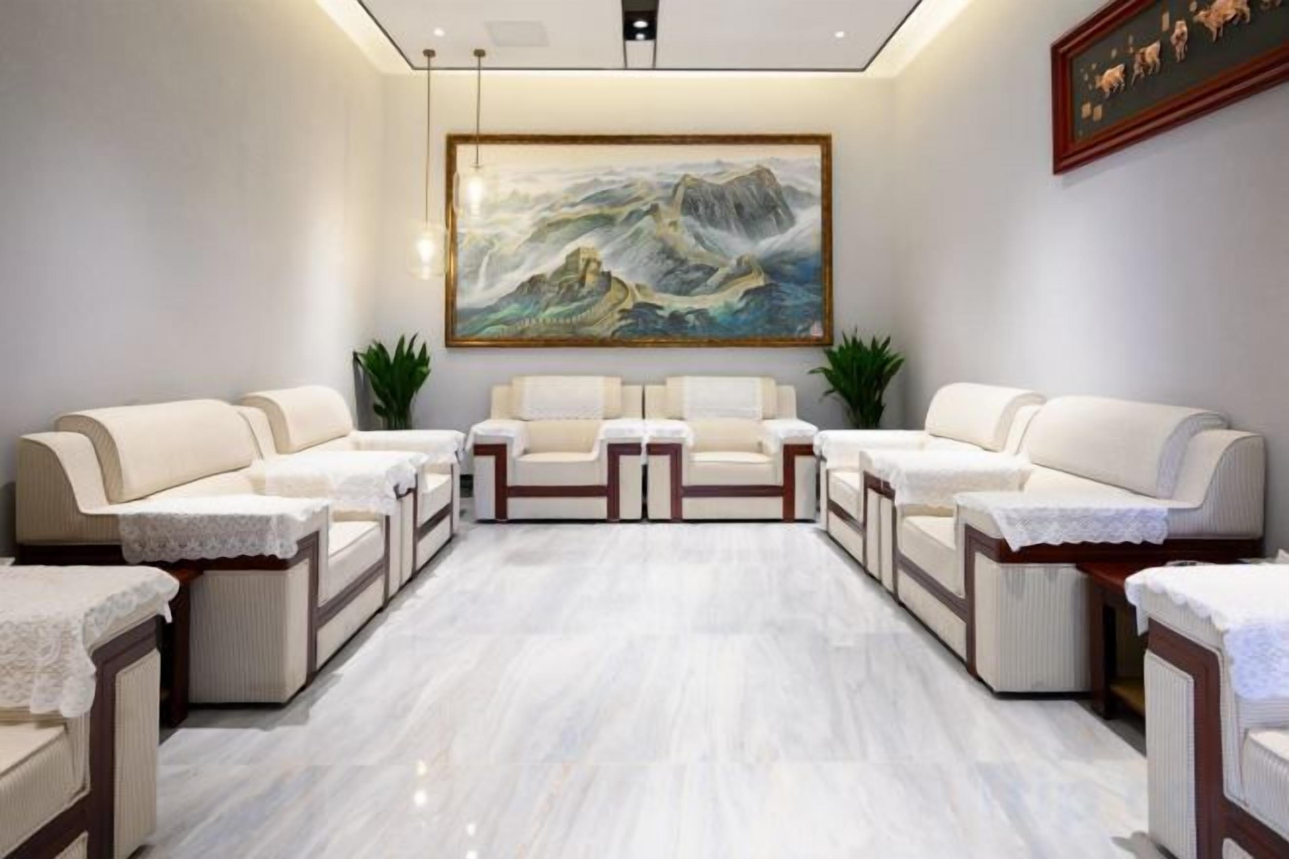 A spa room with a large painting, multiple seating areas, and a marble floor.