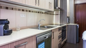 Une cuisine moderne avec des meubles en bois, un évier en acier inoxydable, un lave-vaisselle encastré et une machine à café.