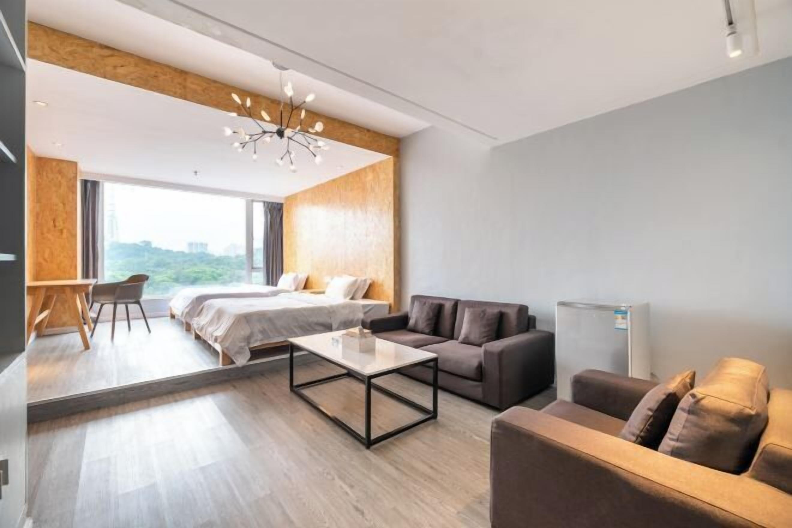 Une chambre d’hôtel moderne équipée d’un lit, d’un canapé, d’une table basse et d’un bureau.