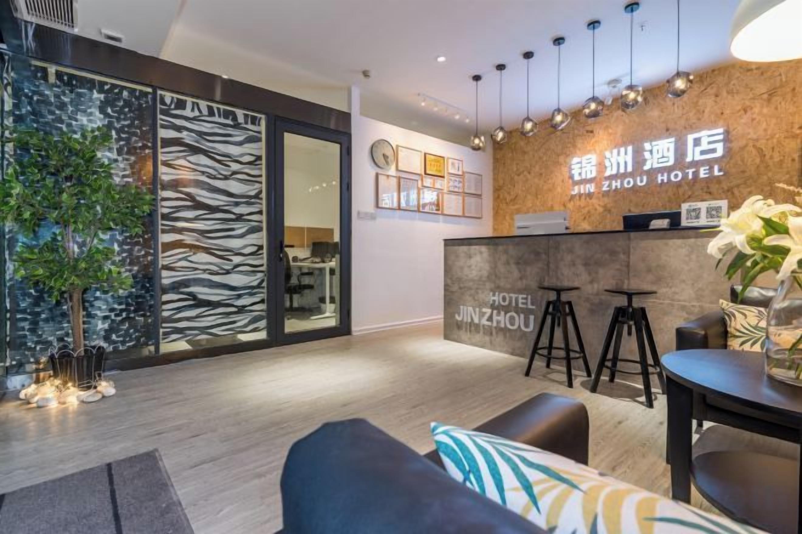 A hotel reception area with a modern design, including a reception desk, seating area, and a plant.