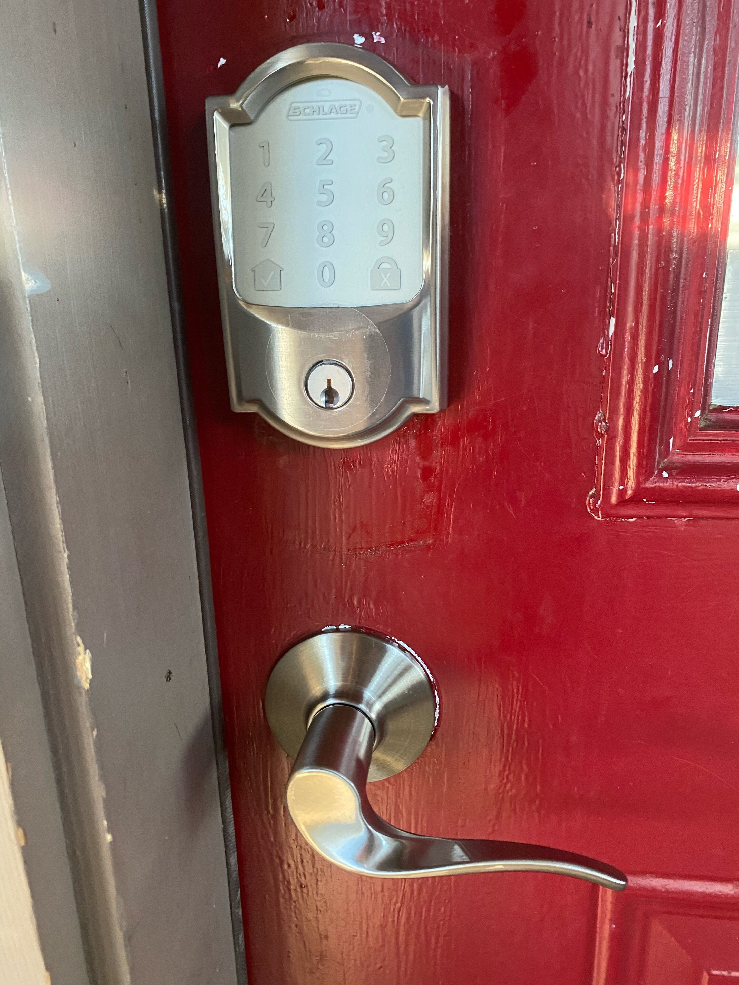 Une porte rouge dotée d’un clavier numérique et d’une poignée à levier.