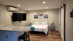 Una camera da letto con un letto, comodini, una scrivania, una sedia e una televisione.