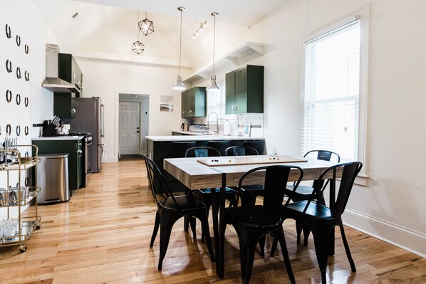 A modern kitchen with a dining area, wooden flooring, and pendant lighting. - Welcome to “The Spot” - North Limestone/Downtown! (Lexington)
