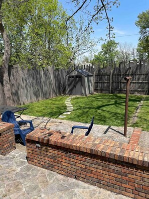 A backyard with a brick patio, a wooden fence, and a shed. - Welcome to “The Spot” - North Limestone/Downtown! (Lexington)