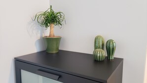 A desk with a potted plant and two decorative cacti. - Cozy, modern 1-bedroom guest suite with backyard ocean view! (Pacifica)