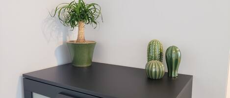 A desk with a potted plant and two decorative cacti.