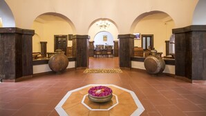 A hotel lobby with arched ceilings, a central seating area, and a decorative flower arrangement. - Krishna Jungle Resort  (Bichhiya)