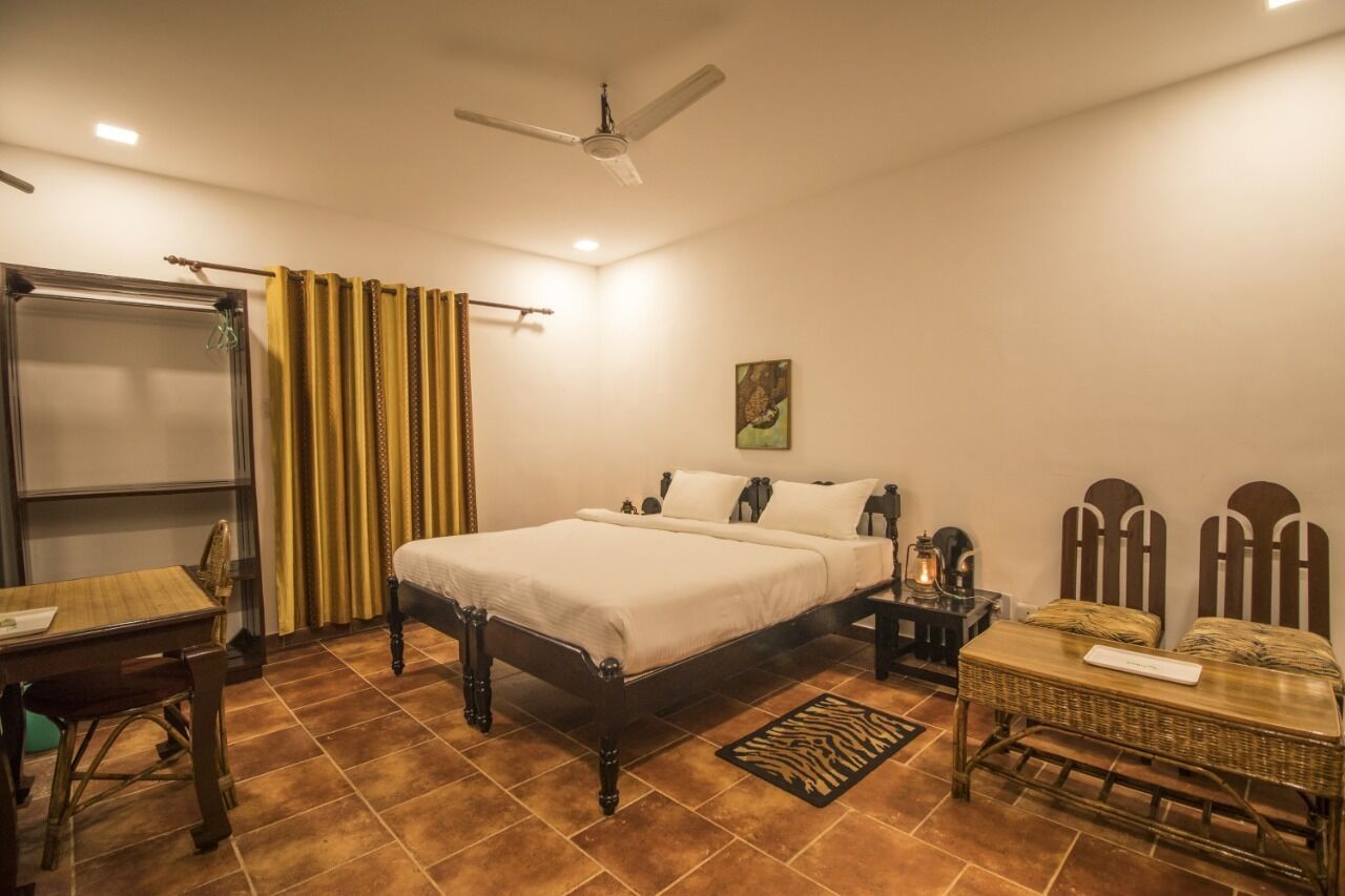 A bedroom with a bed, a nightstand, a table, and a chair.