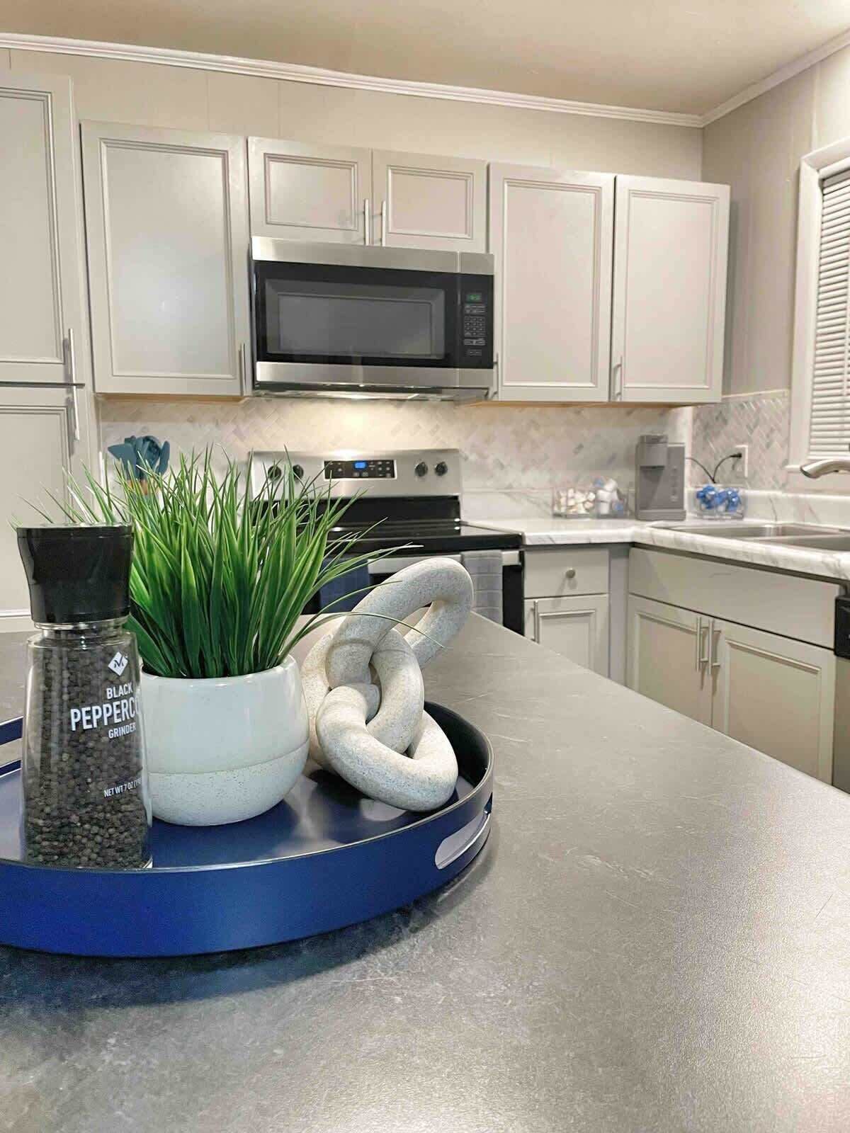 Kitchen with island prep space, microwave, and full stainless appliances.