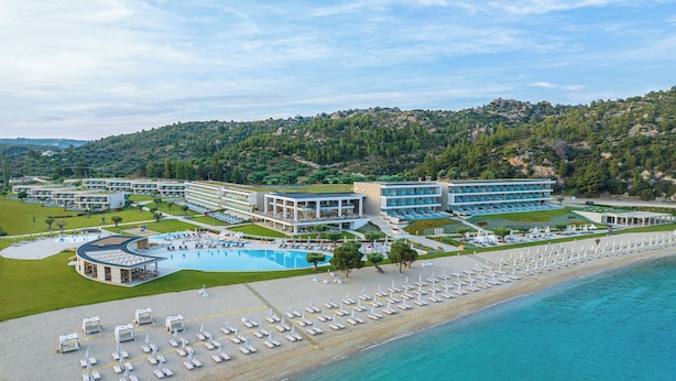 A resort with a large pool, beach area with sun loungers, and multiple hotel buildings. - Ammoa Luxury Hotel & Spa Resort (Sithonia)