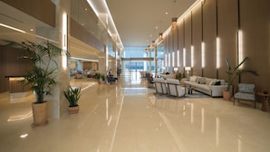 A spacious lobby with a high ceiling, polished floors, and modern furnishings. - Ammoa Luxury Hotel & Spa Resort (Sithonia)