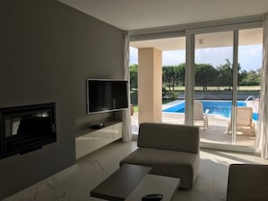 A modern living room with a flat-screen TV, a sofa, and a coffee table.