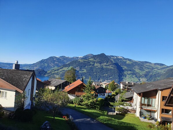 Un barrio residencial con casas, cielo despejado y montañas al fondo.