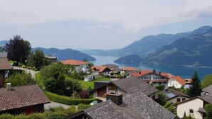Zona residencial con casas y un lago, rodeada de montañas.