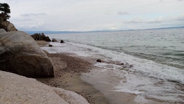 A rocky beach with waves lapping at the shore. - Beautiful Petrino 1880 (Sithonia)
