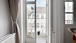A room with a white radiator, a white chair, and a wooden chair near a window. - City 3 - Popular 1-bdr Apt In the Center of Copenhagen (Copenhagen)