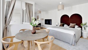 A modern hotel room with a bed, a round dining table, and chairs. - City 3 - Popular 1-bdr Apt In the Center of Copenhagen (Copenhagen)