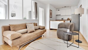 A modern living room with a beige sofa, a grey armchair, and a small side table. - City 3 - Popular 1-bdr Apt In the Center of Copenhagen (Copenhagen)
