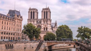 Una catedral histórica con dos torres gemelas, un puente y un río.