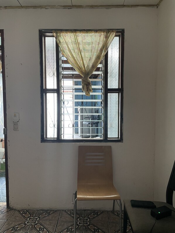 A room with a window, a chair, and a table.