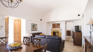 A dining area with a wooden table and chairs, a black leather sofa, and a fireplace. - Hillside villa with pool for 5 guests in Monopoli (Monopoli)