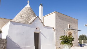 A building with a conical roof, a chimney, and a door. There are potted plants in front. - Hillside villa with pool for 5 guests in Monopoli (Monopoli)