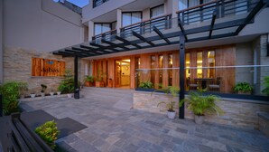 A modern hotel with a stone facade, wooden accents, and a covered outdoor seating area. - Aabas Pokhara by Barahi Hospitality (Pokhara)