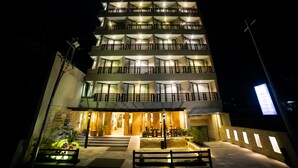 A multi-story hotel with balconies, a well-lit entrance, and a sign indicating it's open. - Aabas Pokhara by Barahi Hospitality (Pokhara)
