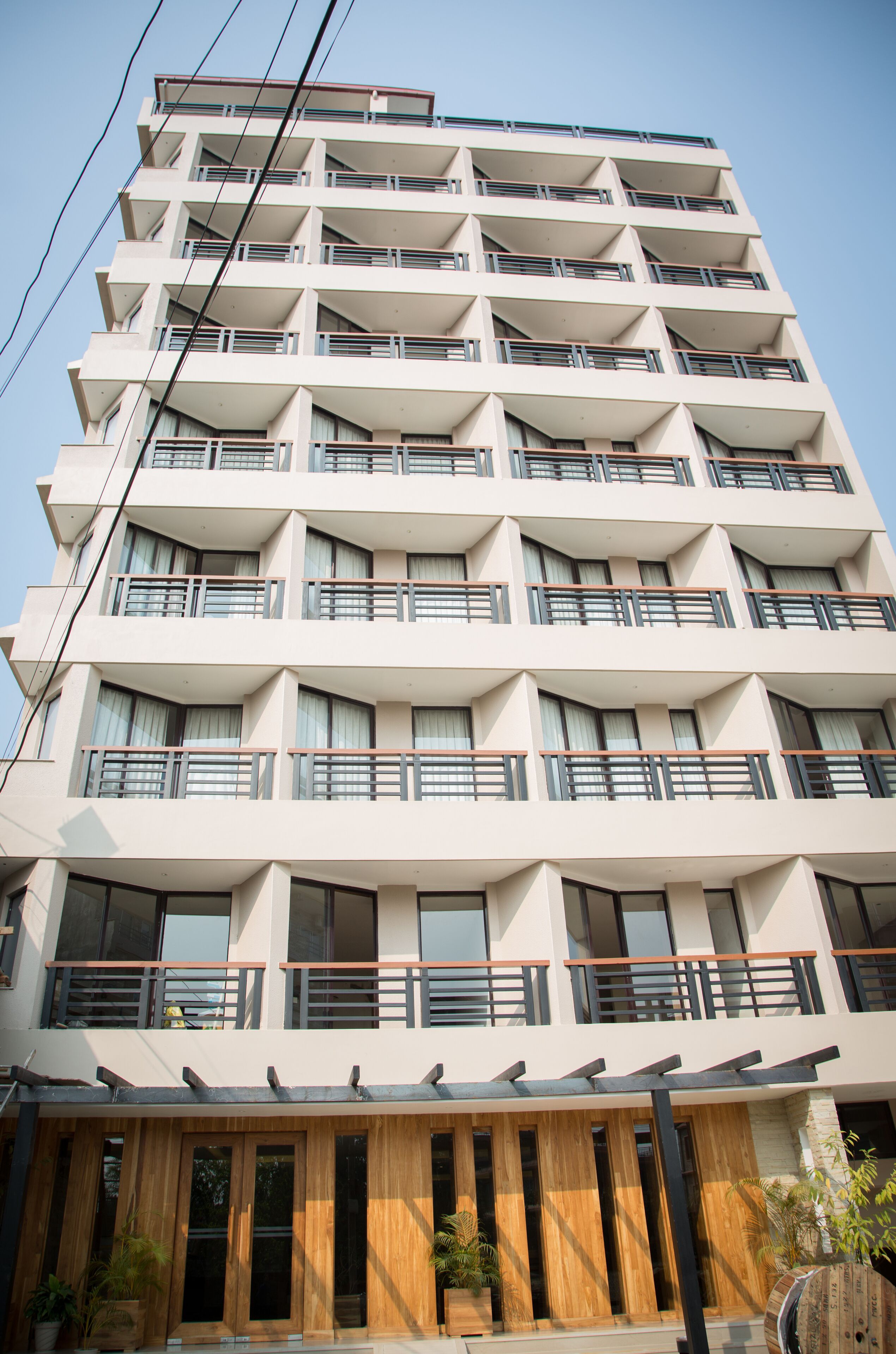 Un hotel de varios pisos con balcones, ventanas amplias y fachada de madera.