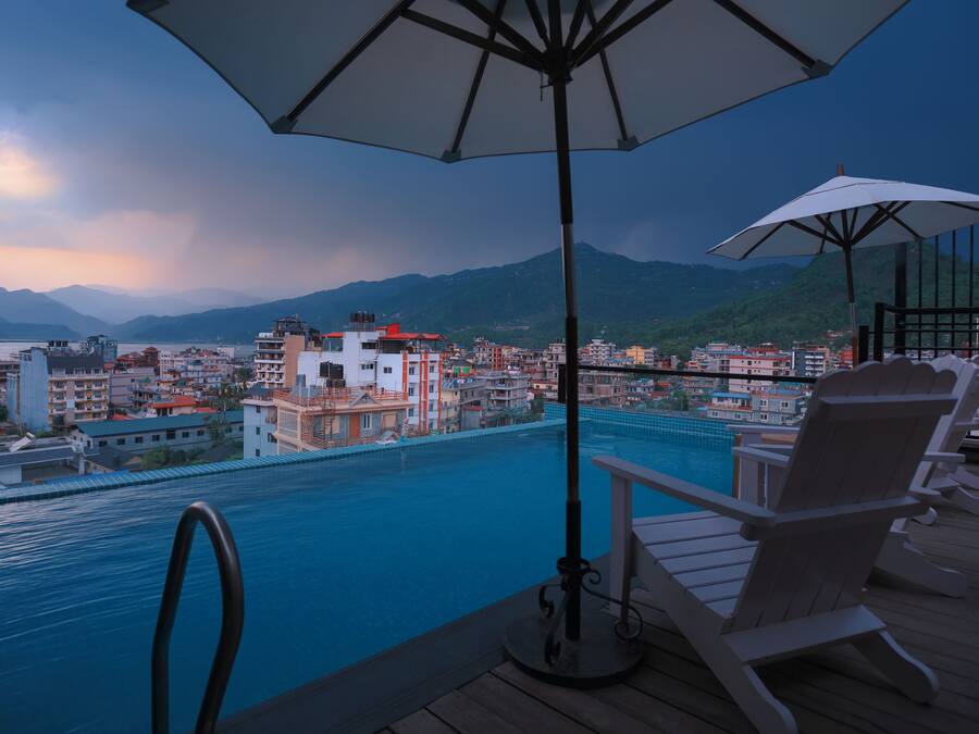 Een buitenzwembad, parasols voor strand/zwembad