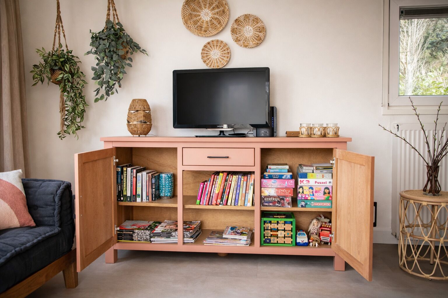 Una sala de estar con televisión, estanterías y objetos decorativos.