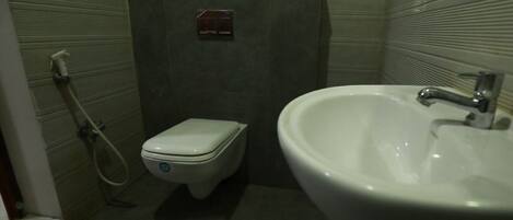 A small bathroom with a toilet, a bidet, and a sink.