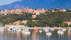 A coastal town with a marina filled with boats, surrounded by hills and buildings. - Spacious, bright apartment on the harbour for 4 to 6 people (Porto-Vecchio)