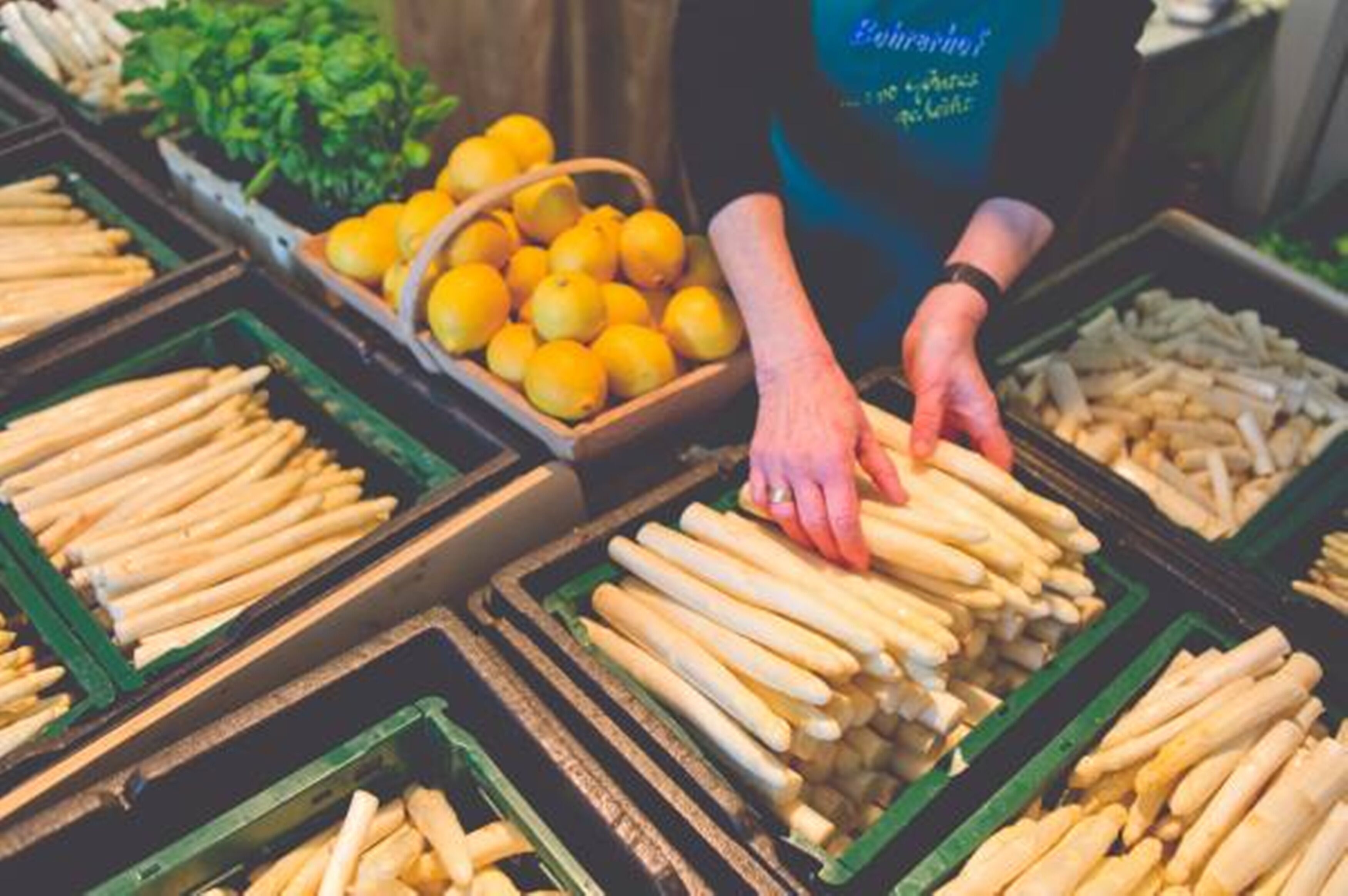 Une personne qui dispose des produits alimentaires sur un étal de marché.